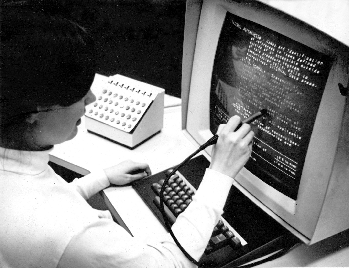 Fotografía de una persona usando la IBM 2250 con un lápiz